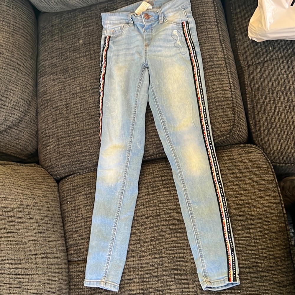 Light jeans with red while and blue strip on the side